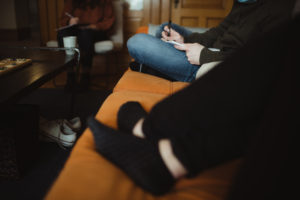 two people sitting on a couch writing