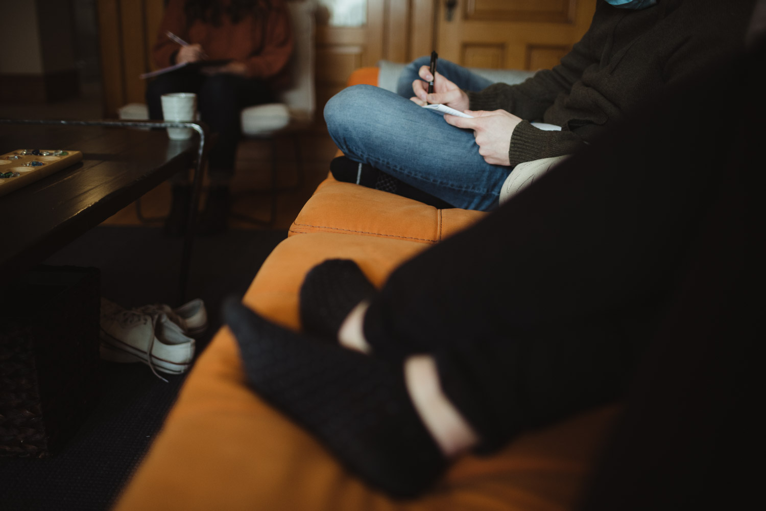 two people sitting on a couch writing