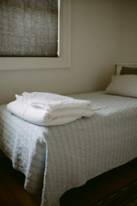 Close up of bed with folded sheets on the end